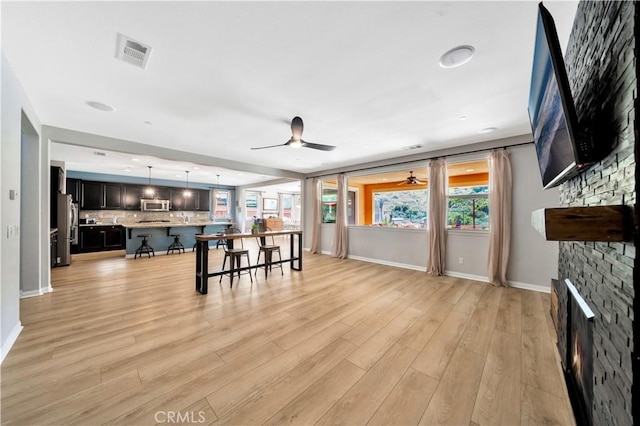 26165 Santiago Canyon Rd, Corona, CA 92883 - living room with light wood finished floors, visible vents, baseboards, and ceiling fan