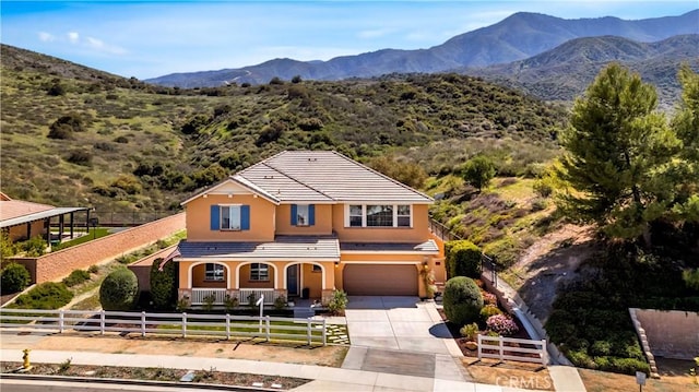 26165 Santiago Canyon Rd, Corona, CA 92883 - view of front facade featuring a garage, a tiled roof, stucco siding, a fenced front yard, and driveway