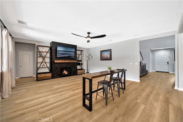 26165 Santiago Canyon Rd, Corona, CA 92883 - dining area with visible vents, a fireplace, light wood-style flooring, a ceiling fan, and baseboards