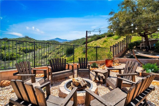 26165 Santiago Canyon Rd, Corona, CA 92883 - view of patio featuring a fire pit, a mountain view, and fence