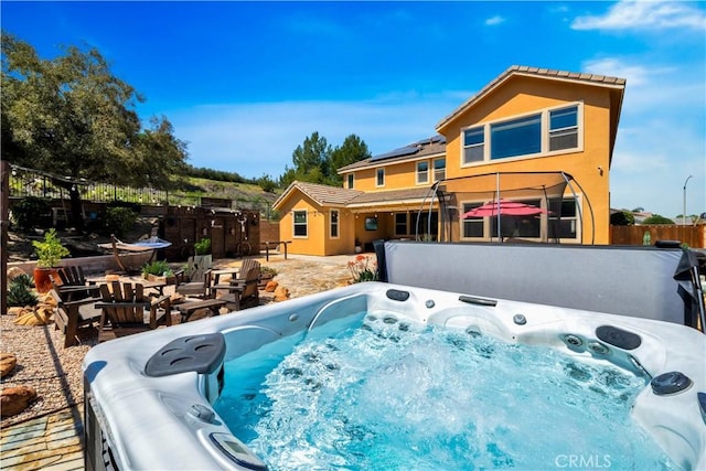 26165 Santiago Canyon Rd, Corona, CA 92883 - rear view of house with a hot tub, fence, solar panels, stucco siding, and a tile roof