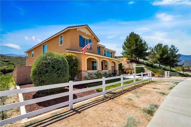 26165 Santiago Canyon Rd, Corona, CA 92883 - mediterranean / spanish house with covered porch, stone siding, a mountain view, stucco siding, and a fenced front yard