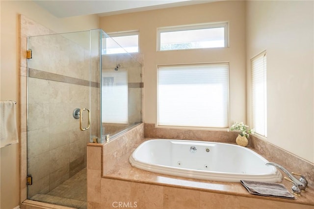 full bath with a shower stall and a jetted tub