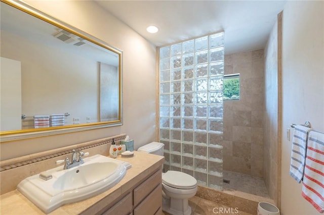 full bath with toilet, vanity, visible vents, and walk in shower