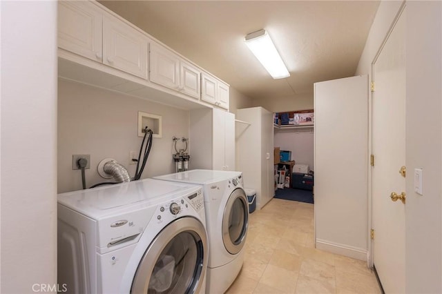 laundry room with independent washer and dryer and cabinet space