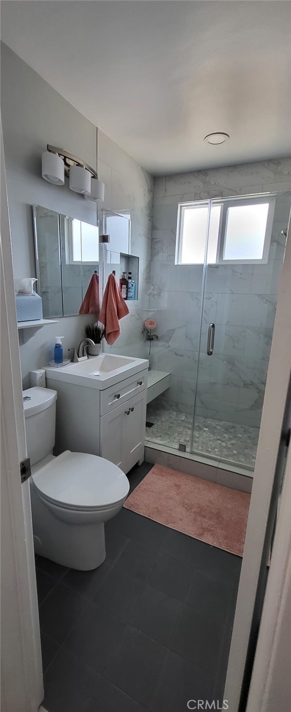 full bath featuring tile patterned flooring, vanity, toilet, and a stall shower