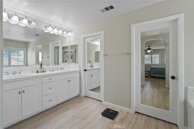 29851 Fox Creek Dr, Menifee, CA 92586 - bathroom featuring wood finished floors, connected bathroom, double vanity, and a ceiling fan