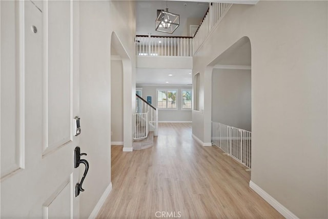 29851 Fox Creek Dr, Menifee, CA 92586 - foyer entrance featuring arched walkways, baseboards, a chandelier, wood finished floors, and stairs