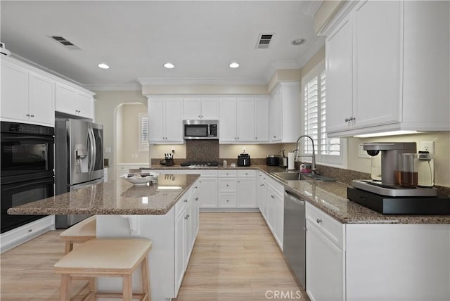 29851 Fox Creek Dr, Menifee, CA 92586 - kitchen featuring stainless steel appliances, a sink, crown molding, arched walkways, and a center island