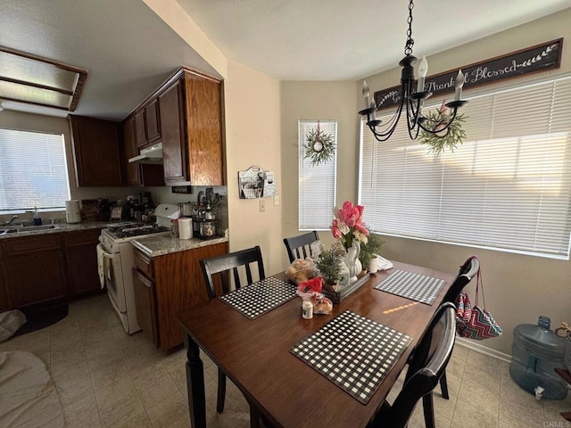 dining area featuring light tile patterned floors, baseboards, and a notable chandelier