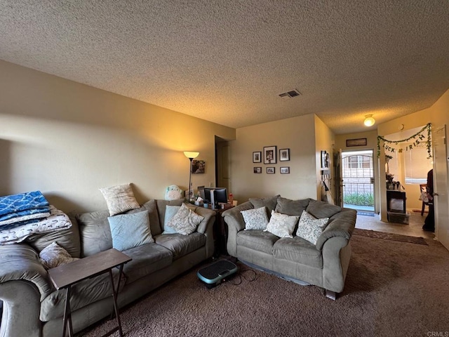 carpeted living area with visible vents and a textured ceiling
