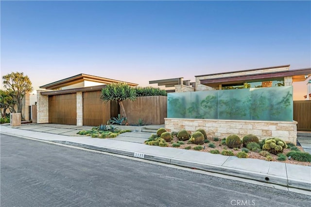 1231 Dolphin, Corona Del Mar, CA 92625 - view of front facade with stone siding, a garage, and fence