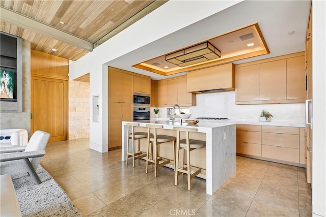 1231 Dolphin, Corona Del Mar, CA 92625 - kitchen featuring a tray ceiling, light countertops, a kitchen breakfast bar, appliances with stainless steel finishes, and premium range hood