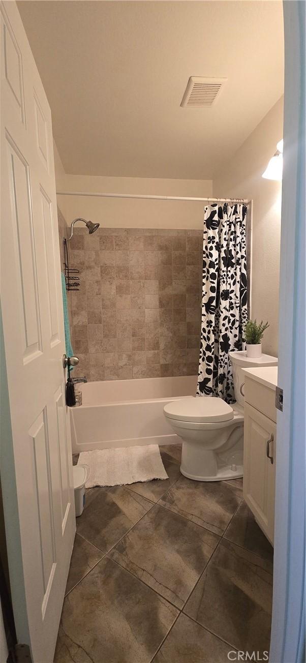 full bath with visible vents, toilet, and tile patterned floors
