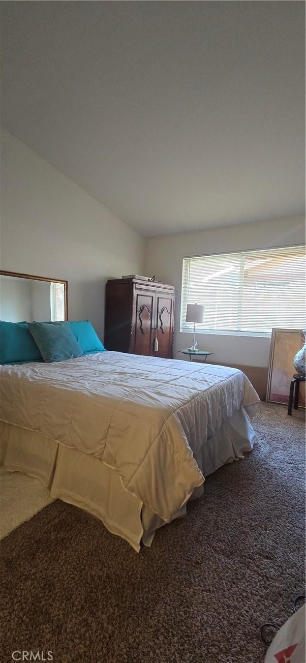 carpeted bedroom with vaulted ceiling