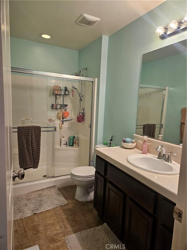 1445 Sandy Hill Dr, Calimesa, CA 92320 - full bath with a shower stall, visible vents, toilet, vanity, and a textured ceiling