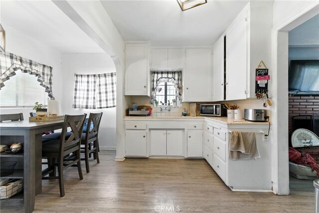 2965 Poplar Dr, Lynwood, CA 90262 - kitchen with stainless steel microwave, light countertops, white cabinetry, and light wood finished floors