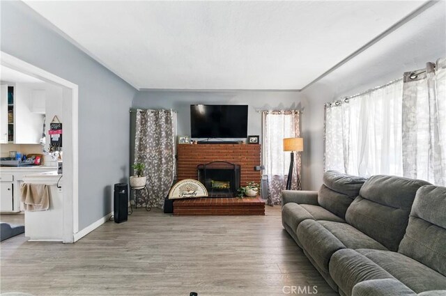 2965 Poplar Dr, Lynwood, CA 90262 - living area with light wood finished floors and a brick fireplace