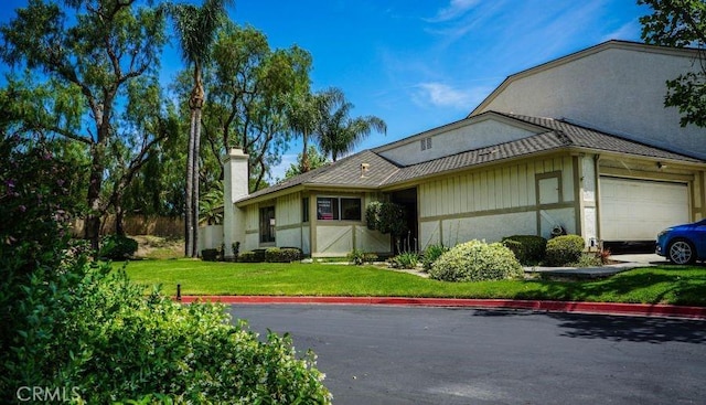 1725 Truman Cir, Placentia, CA 92870 - view of front of home with an attached garage, a front yard, a chimney, and stucco siding