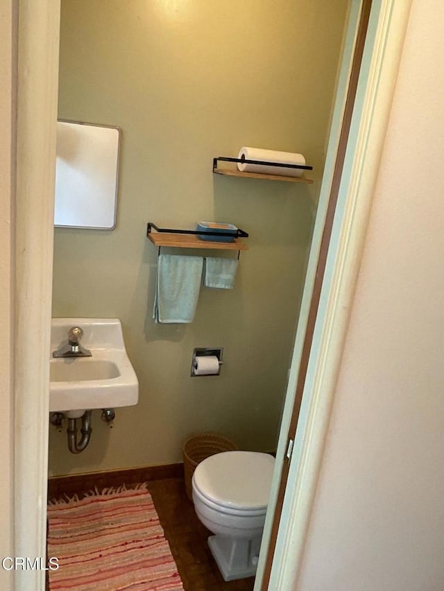 bathroom with baseboards, a sink, and toilet