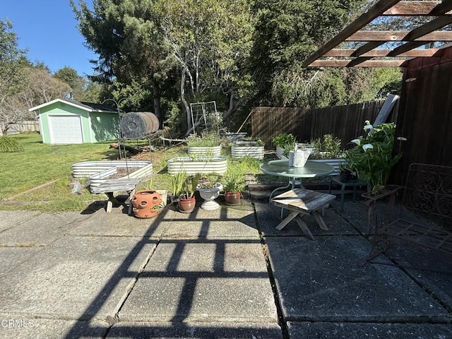 view of patio / terrace featuring an outdoor structure, fence, a storage shed, and a pergola