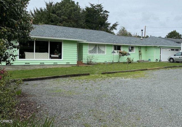 view of front facade featuring a garage, roof with shingles, and a front yard