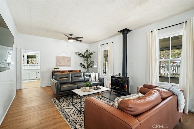 2007 3rd St, Julian, CA 92036 - living room featuring baseboards, a wood stove, light wood-type flooring, and a ceiling fan