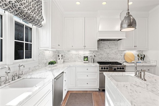kitchen featuring custom range hood, a sink, stainless steel appliances, and white cabinetry