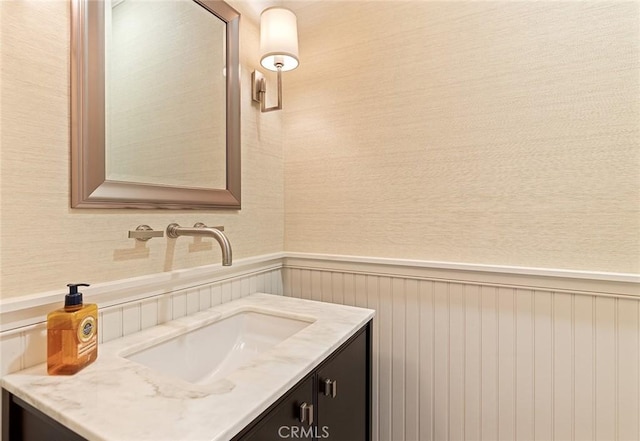 bathroom with a wainscoted wall and vanity