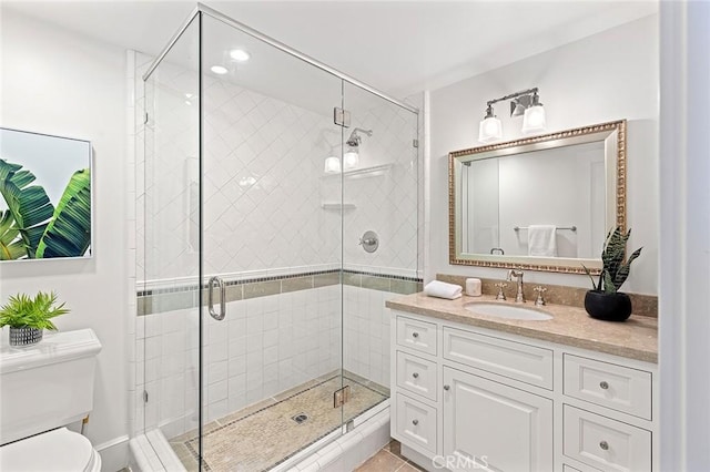 bathroom with toilet, vanity, and a shower stall