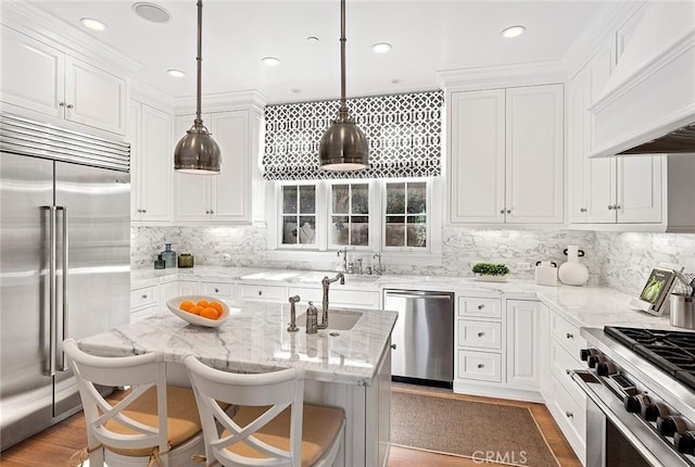 kitchen with custom exhaust hood, high end appliances, white cabinetry, light wood-style floors, and light stone counters