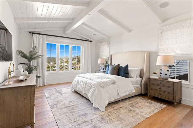bedroom featuring lofted ceiling with beams, baseboards, and hardwood / wood-style floors