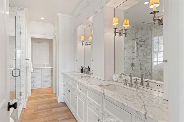 full bath featuring a shower stall, ornamental molding, and a sink