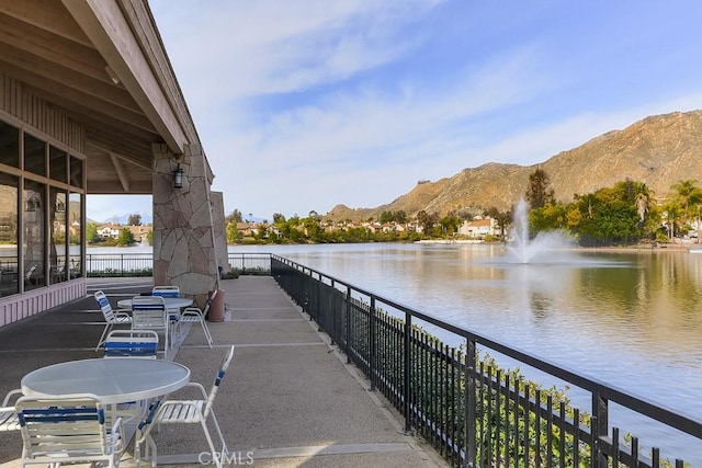 view of patio / terrace with a water and mountain view