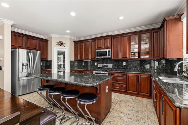 kitchen featuring a breakfast bar area, stainless steel appliances, a center island, decorative backsplash, and a sink