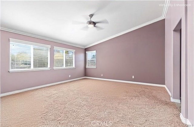 carpeted spare room featuring baseboards, a ceiling fan, and crown molding