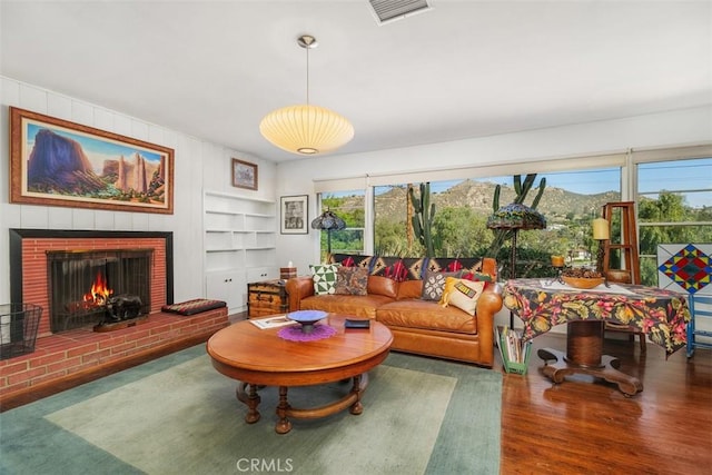 4365 Alta Vista Dr, Riverside, CA 92506 - living room with plenty of natural light, built in shelves, wood finished floors, and a fireplace