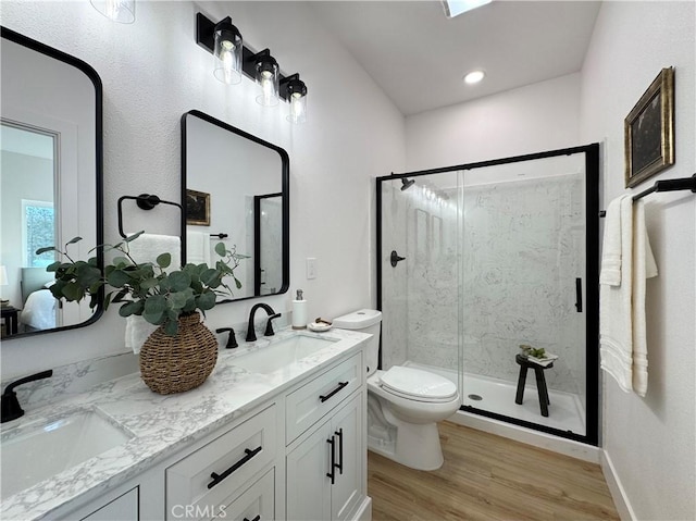 bathroom with toilet, a marble finish shower, a sink, and wood finished floors