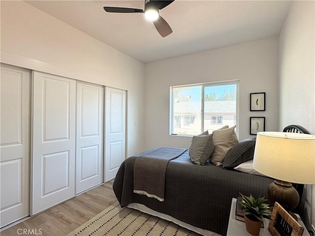bedroom with a ceiling fan, light wood finished floors, and a closet