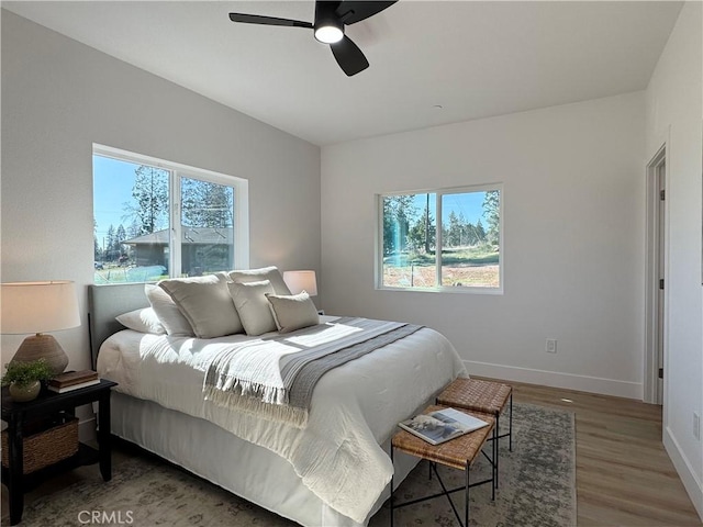 bedroom featuring baseboards, ceiling fan, and wood finished floors