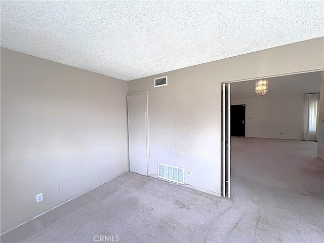 4971 W Gilman St, Banning, CA 92220 - carpeted empty room with a chandelier and a textured ceiling