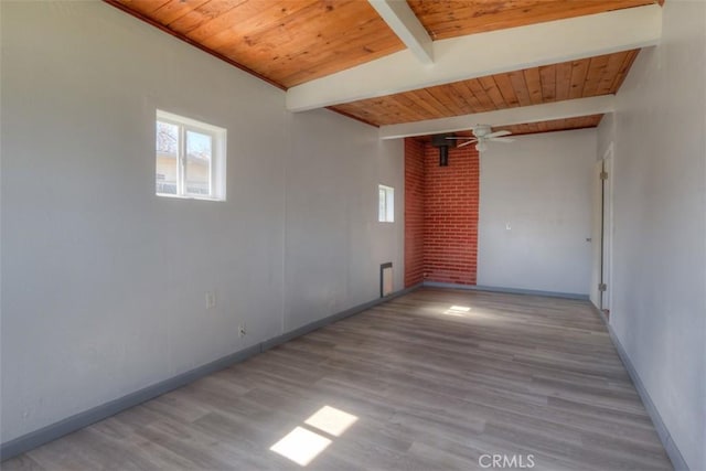 spare room featuring baseboards, wood finished floors, a ceiling fan, beam ceiling, and wood ceiling
