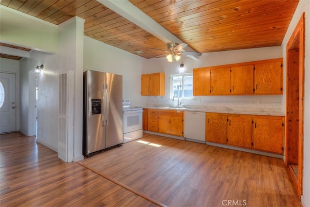 kitchen featuring light wood-type flooring, light countertops, a sink, and white appliances