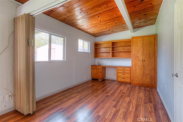 unfurnished office with built in study area, wooden ceiling, lofted ceiling with beams, baseboards, and wood finished floors
