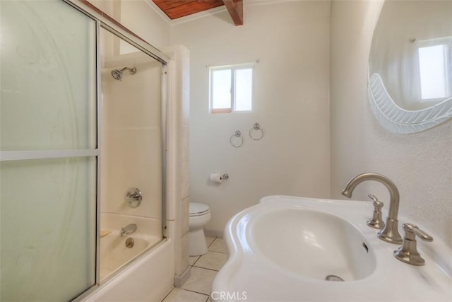 bathroom with bath / shower combo with glass door, toilet, tile patterned flooring, and a sink