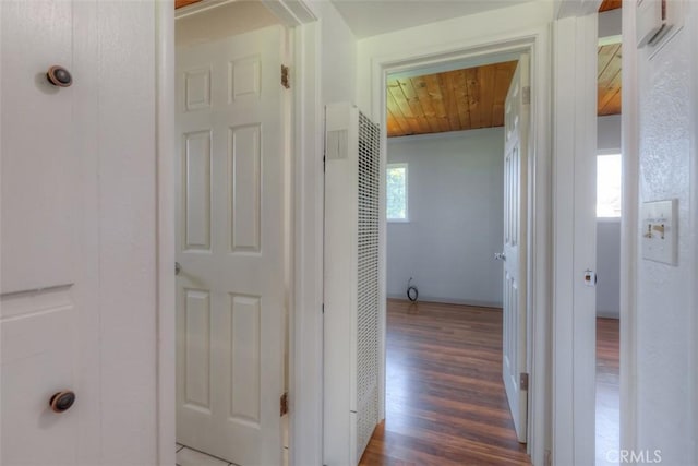 hallway featuring wood finished floors, wood ceiling, and a heating unit