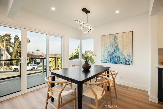 dining area featuring recessed lighting, light wood-style flooring, baseboards, and an inviting chandelier