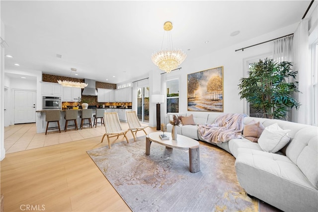 living area featuring an inviting chandelier, recessed lighting, and light wood-style flooring