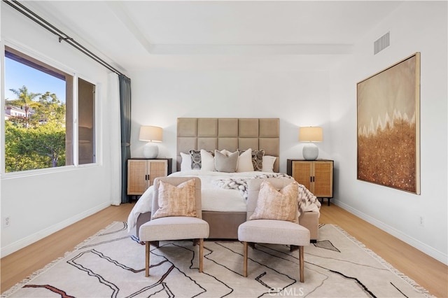 bedroom featuring baseboards, visible vents, and light wood-style flooring