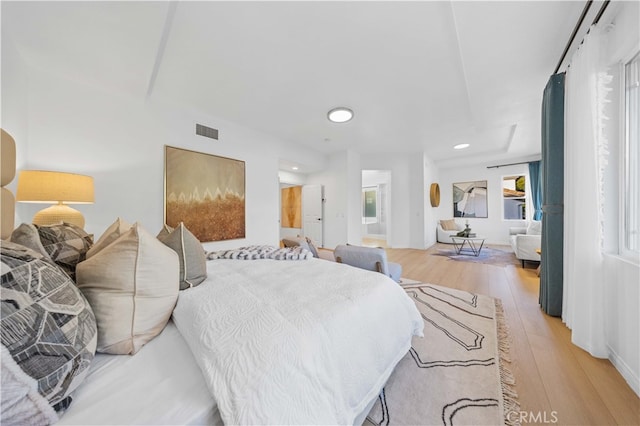 bedroom featuring ensuite bath, recessed lighting, light wood-style flooring, and visible vents